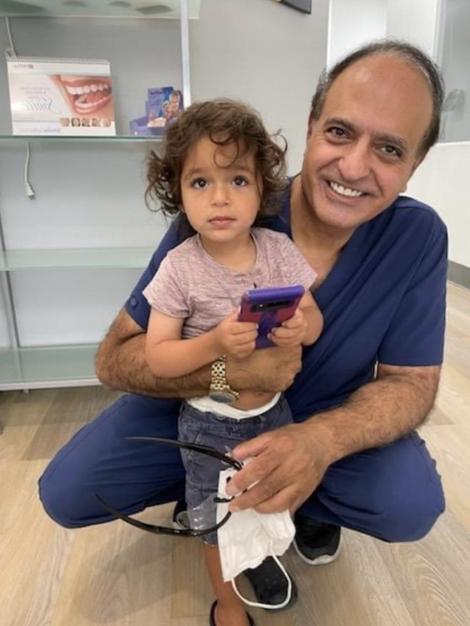 An image of Dr. Robert Khanian with a little girl in his dental office in Tarzana, California