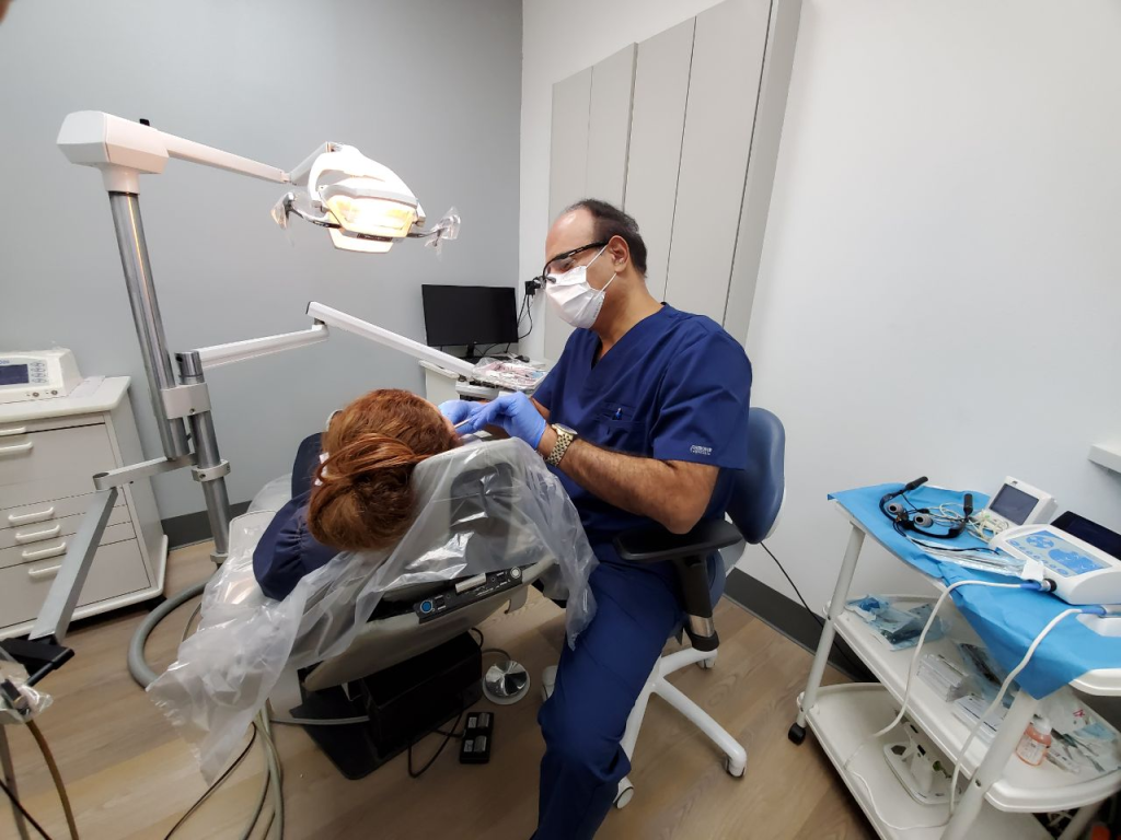 Dr. Khanian from All Smiles Family Dentistry checking a female patient in his dental office in Tarzana