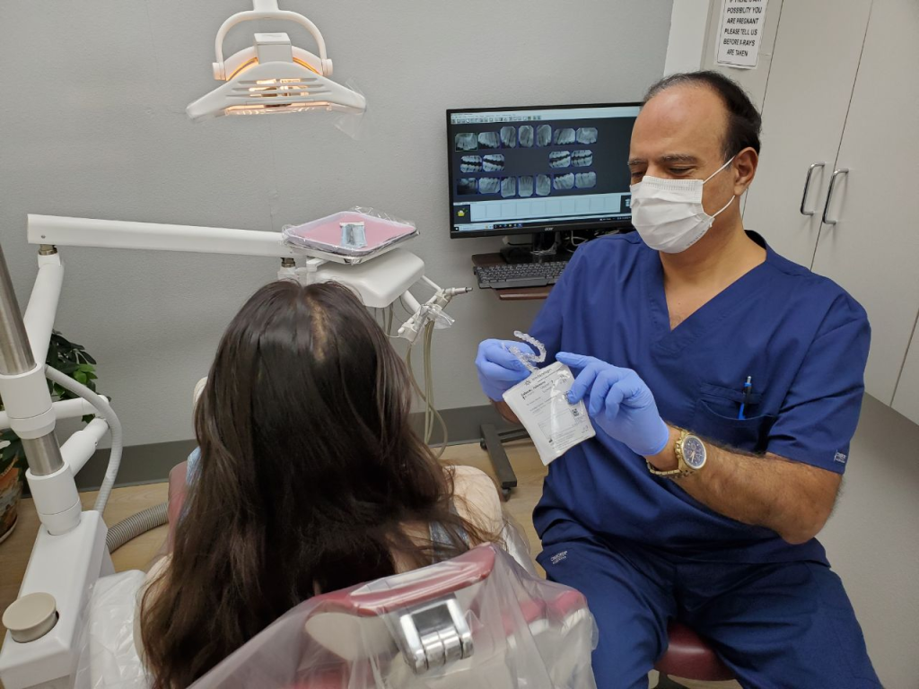 A woman getting a dental checkup from All Smiles Family Dentistry's Dr. Khanina