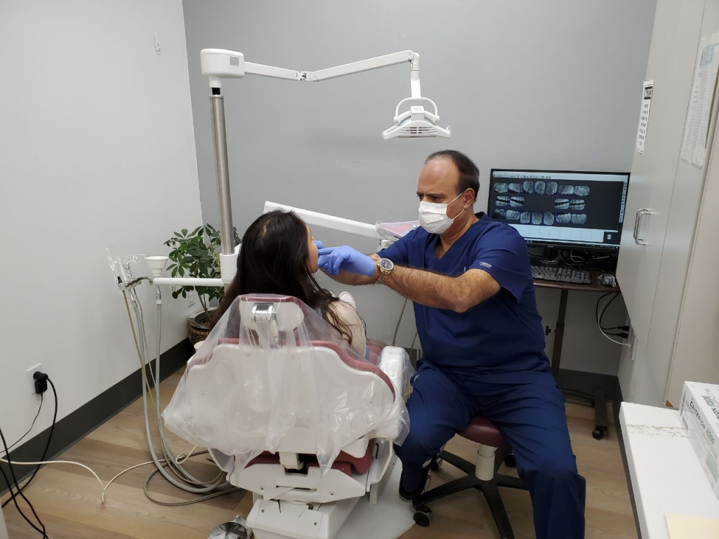A woman getting a dental checkup from All Smiles Family Dentistry's Dr. Khanian