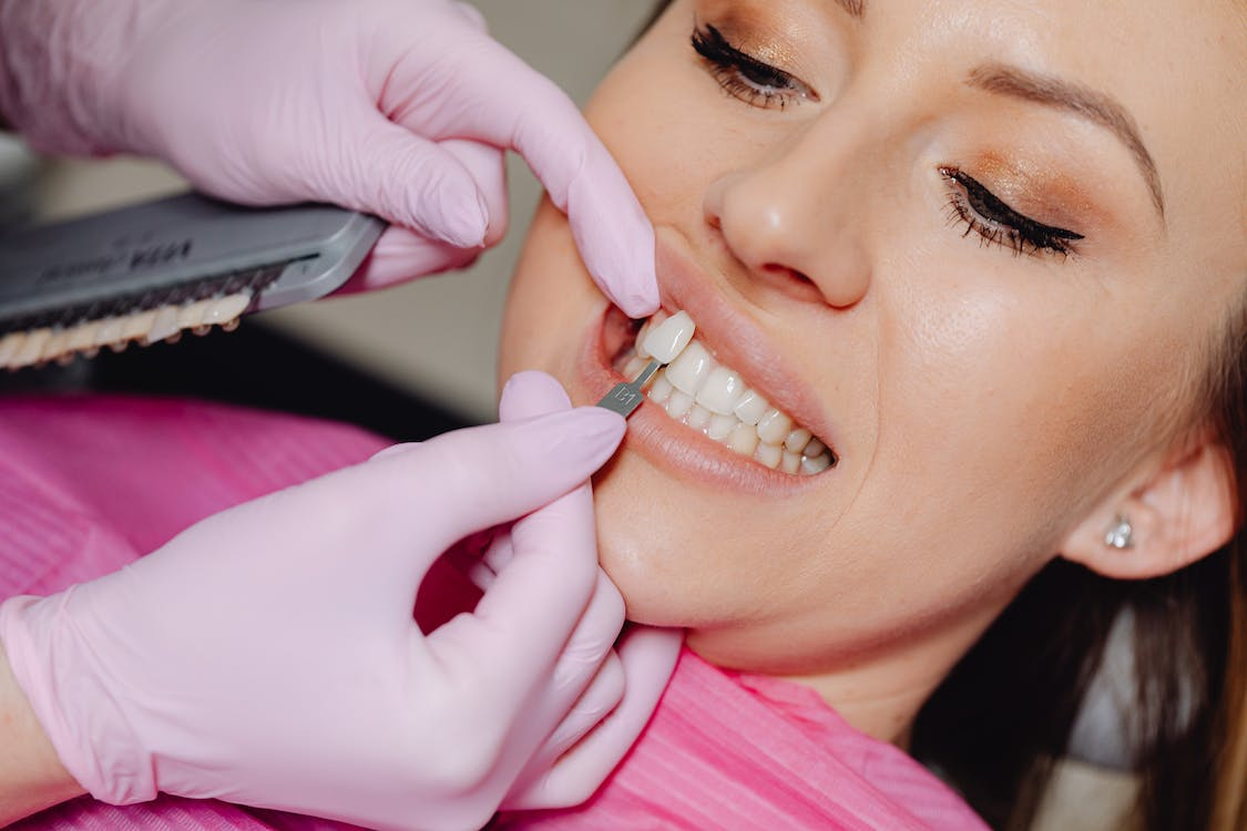 A dentist applying veneer tooth on a patient