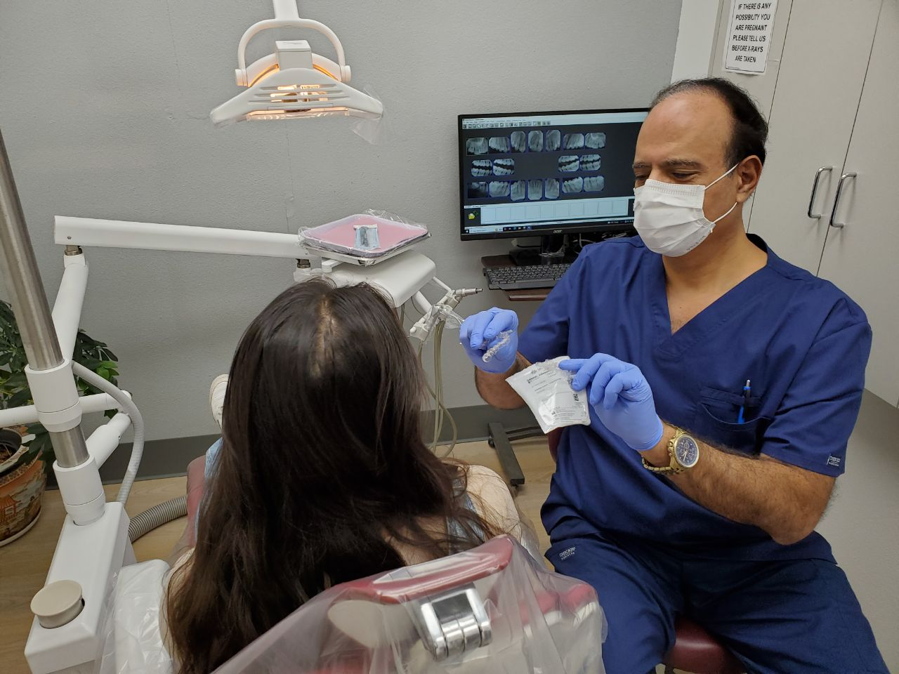 Dr. Khanina from All Smiles Family Dentistry showing Invisalign to a female patient