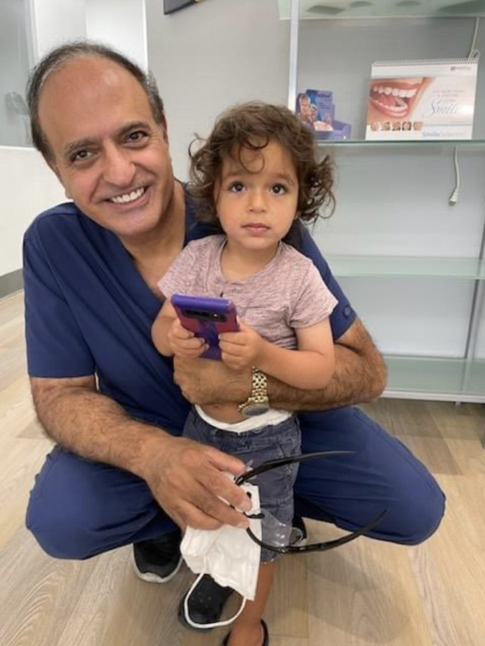 Dr. Khanian taking a picture with a child patient